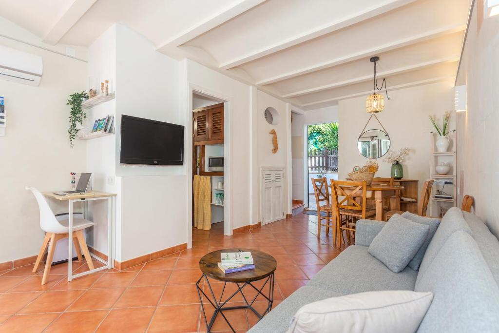 ein Wohnzimmer mit einem Sofa und einem Tisch in der Unterkunft Arbocers in Ciutadella