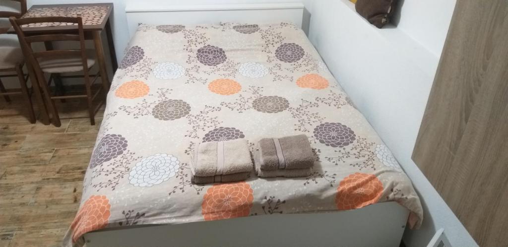 a bed with a comforter on top of it at Petkovic Apartmani 3 in Tivat