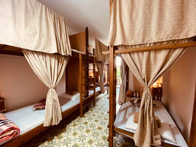 two bunk beds with drapes in a room at Chủ Nhật Cafe & Homestay - 12 ngõ 41 Đường Láng - Cơ sở 1 in Hanoi