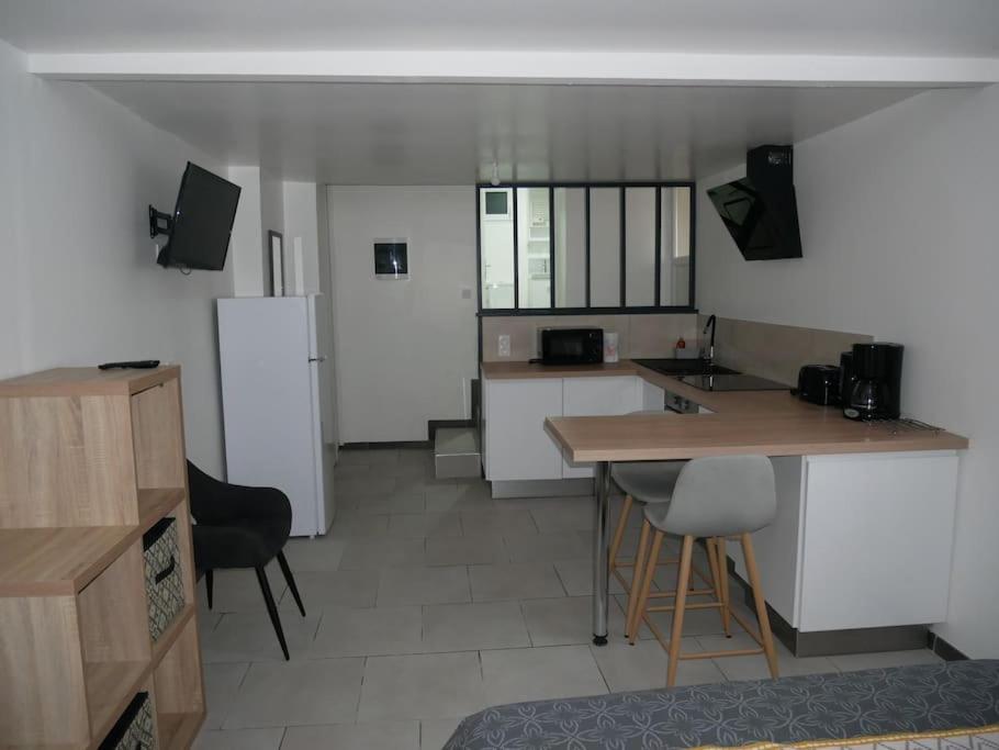 a kitchen with a counter and a refrigerator at Studio Indépendant, au calme. in La Roche-sur-Yon