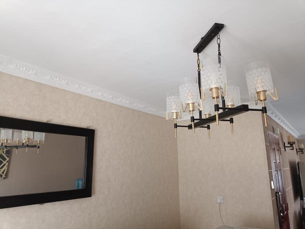 a chandelier in a room with a mirror and a wall at BELLS TRIAD - FREE TRANSPORT FROM AIRPORT FOR PRE PAYMENT BOOKINGs in Nairobi
