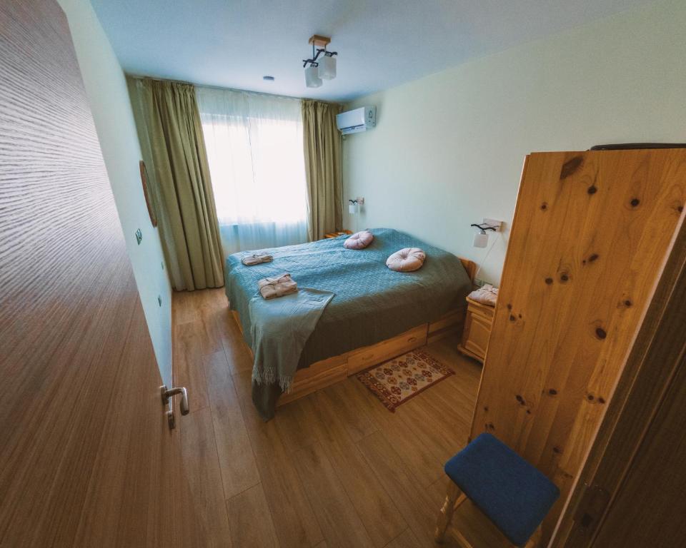 una camera da letto con un letto e un pavimento in legno di Riverpark Holiday Apartment, Sandanski a Sandanski