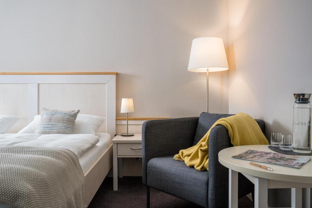 ビューズムにあるAkzent Hotel Dornのベッド、ソファ、テーブルが備わるホテルルームです。