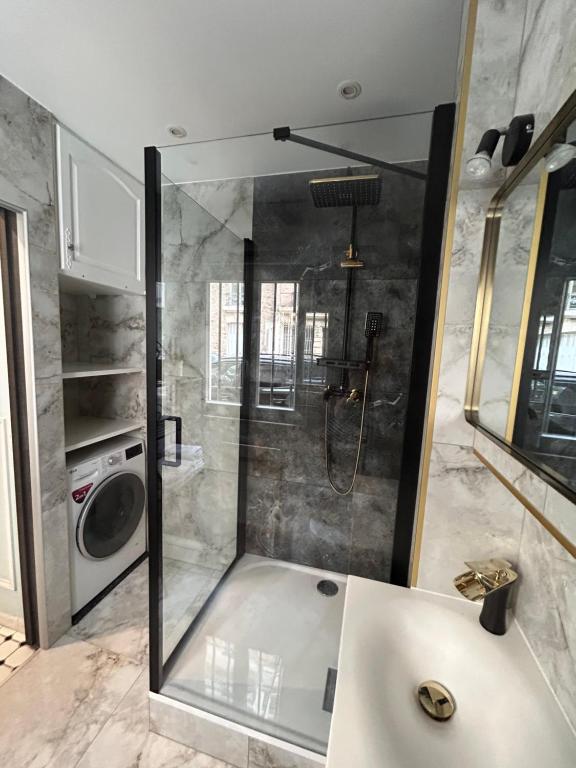 a bathroom with a shower with a sink and a washing machine at Loft 5 places with view on Eiffel Tower in Paris