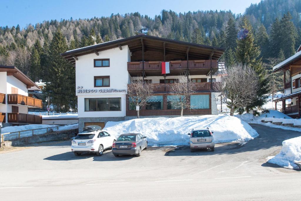 three cars parked in a parking lot in front of a building at Garni Norma in Madonna di Campiglio