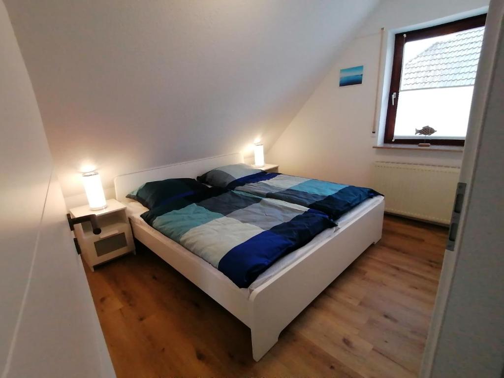 a bedroom with a bed with two lamps on it at Dünenrose in Horumersiel