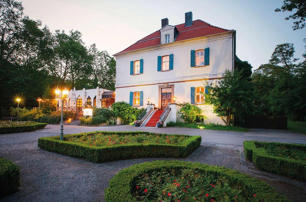 ein großes weißes Haus mit rotem Dach in der Unterkunft Vienna House Easy by Wyndham Castrop-Rauxel in Castrop-Rauxel