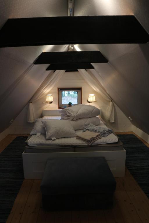 una camera con letto nel mezzo di una mansarda di Comfy Guest House in Countryside a Lövestad