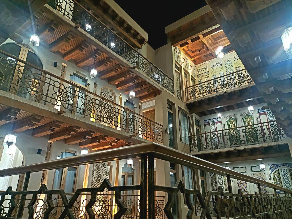 a building with balconies and a spiral staircase at Latifa Begim Boutique Hotel in Bukhara