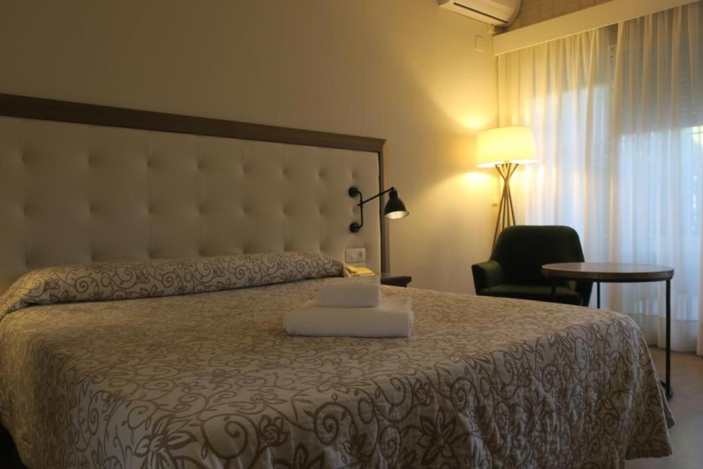 1 dormitorio con 1 cama con ordenador portátil en Hotel Playa Canet, en Canet de Berenguer