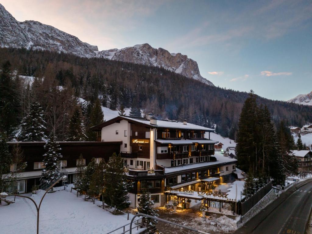 ein großes Haus in den Bergen mit Schnee in der Unterkunft Sporthotel Teresa in Abtei
