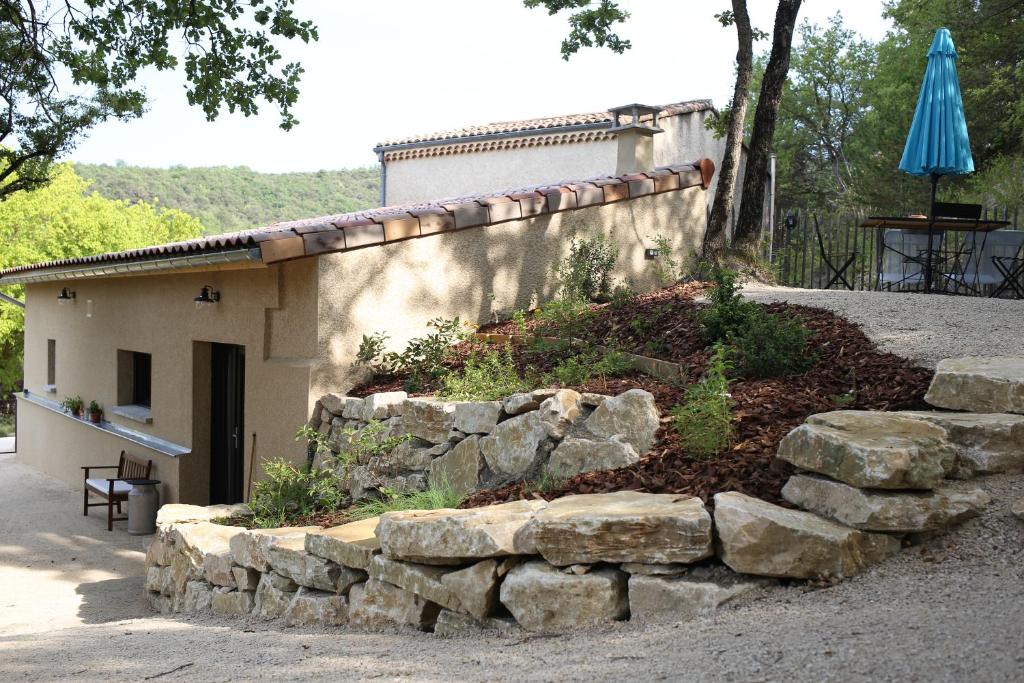 a stone retaining wall in front of a building at L'Embellie, maisonnette tout confort en pleine nature in Suze