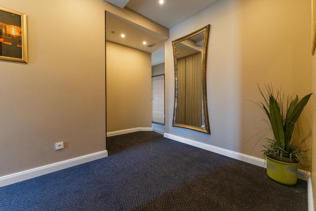 a hallway with a mirror and a plant at Hotel Sky in Zadar