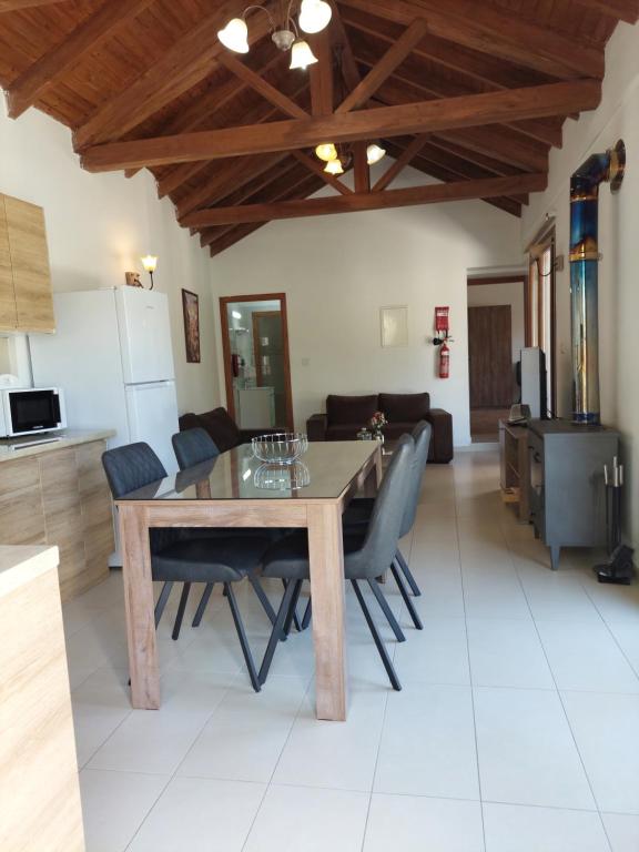 una sala da pranzo e una cucina con tavolo e sedie in legno di Love Holiday Suite 2 a Tris Elies