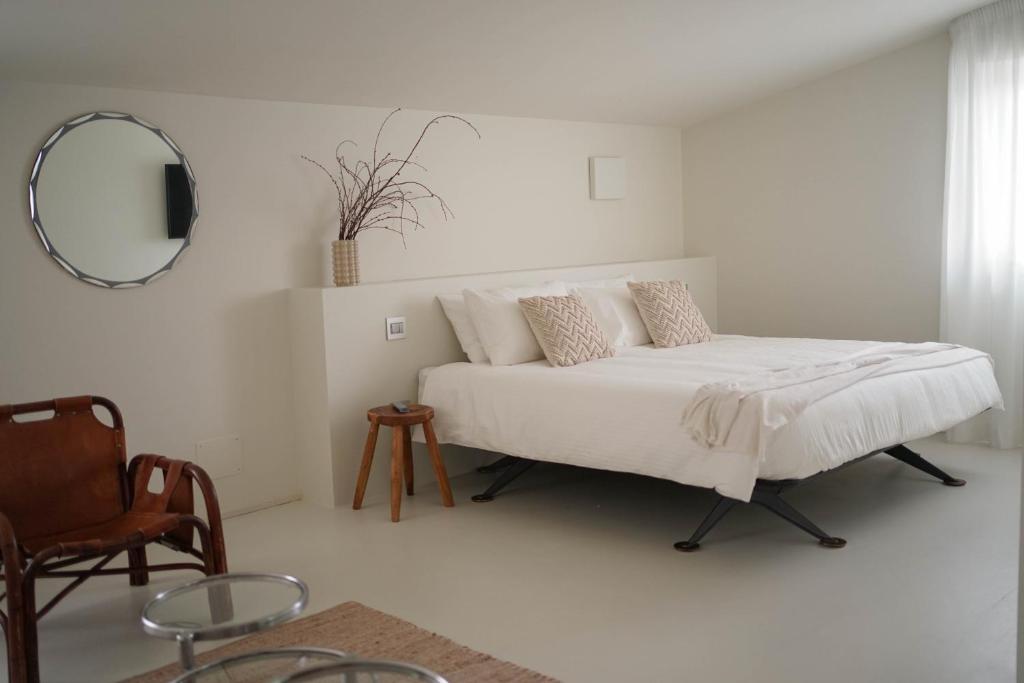 um quarto com uma cama com um espelho e uma cadeira em Parisina Design Rooms em Pescara