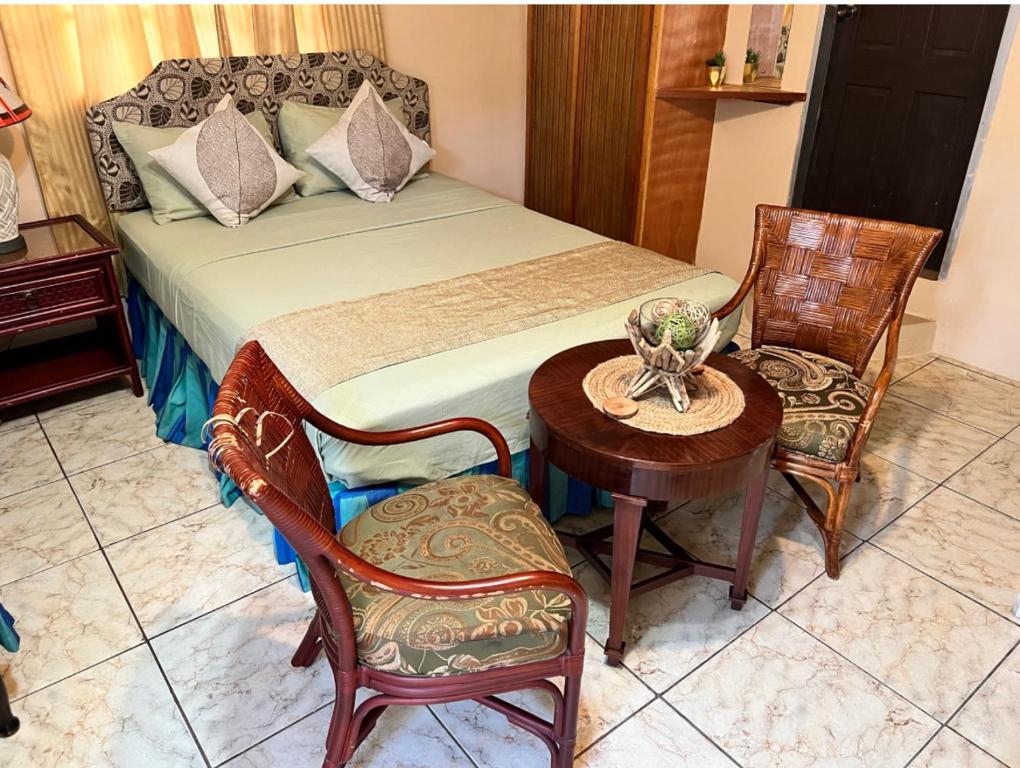 a bedroom with a bed with a table and chairs at Shirvan Holiday Apartments Studio in Canaan