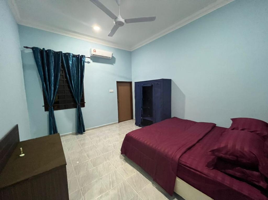 ein Schlafzimmer mit einem Bett und einem TV in der Unterkunft IJW HOMESTAY in Kuala Terengganu