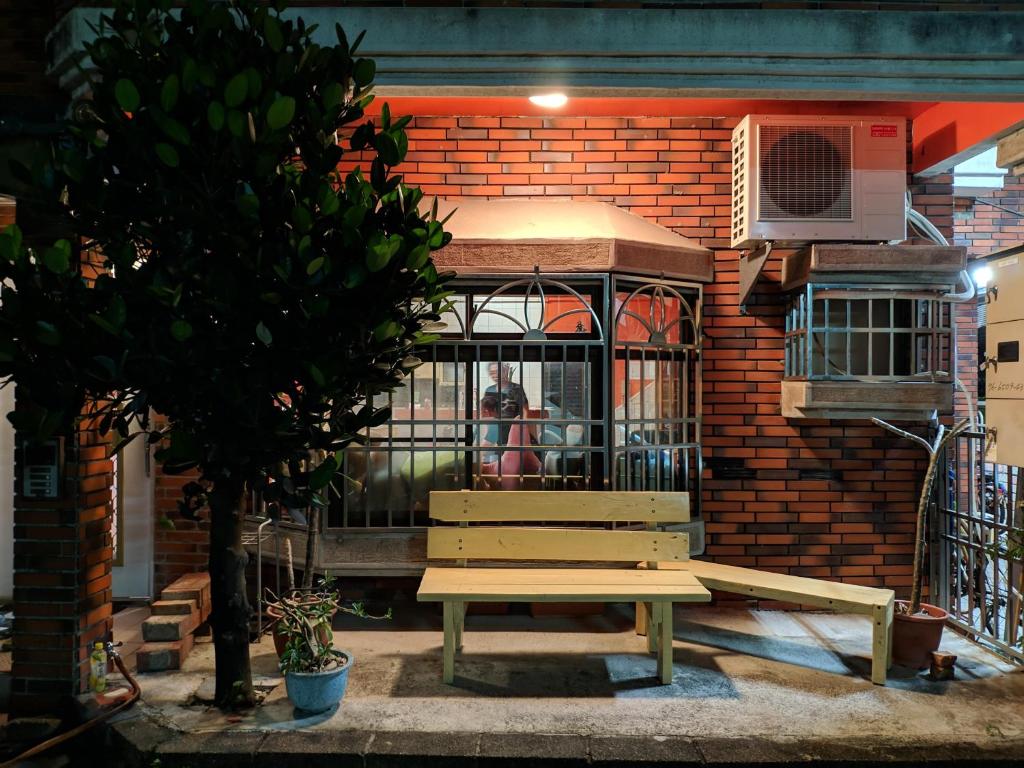 a bird cage with a bench in front of a building at 蘇馬利萬巒民宿 in Wanluan