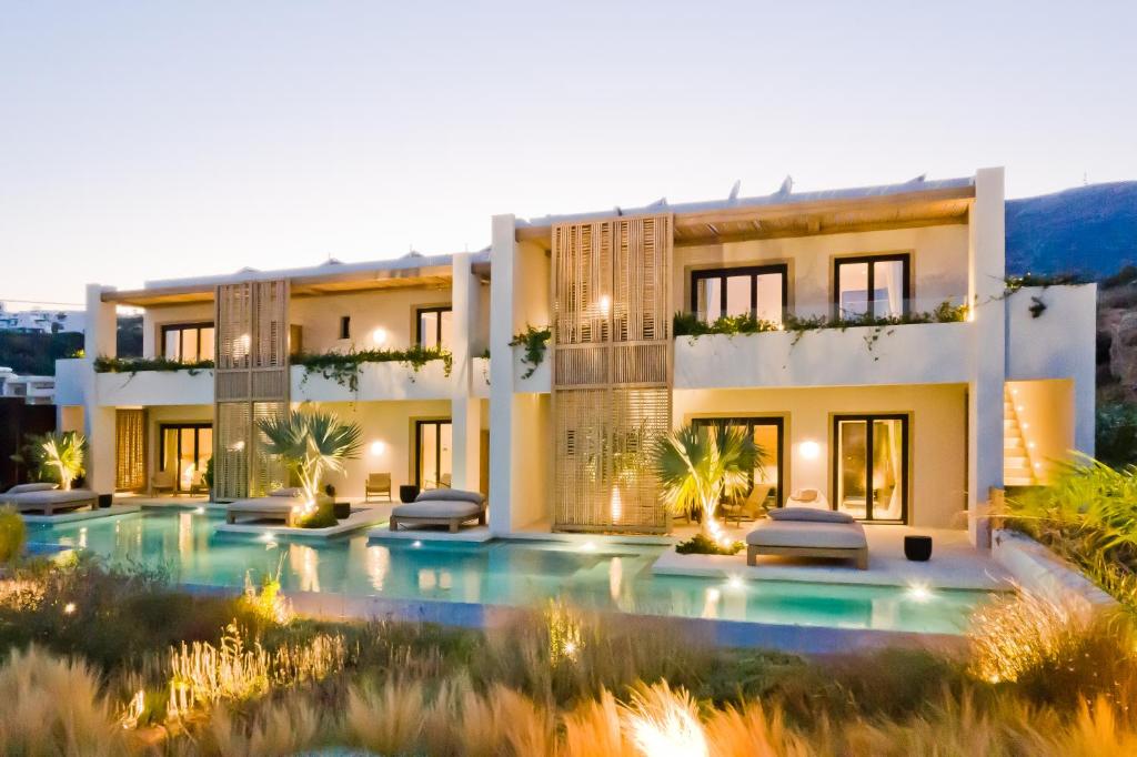 una casa grande con piscina frente a ella en Almi Luxury Rooms, en Amoopi