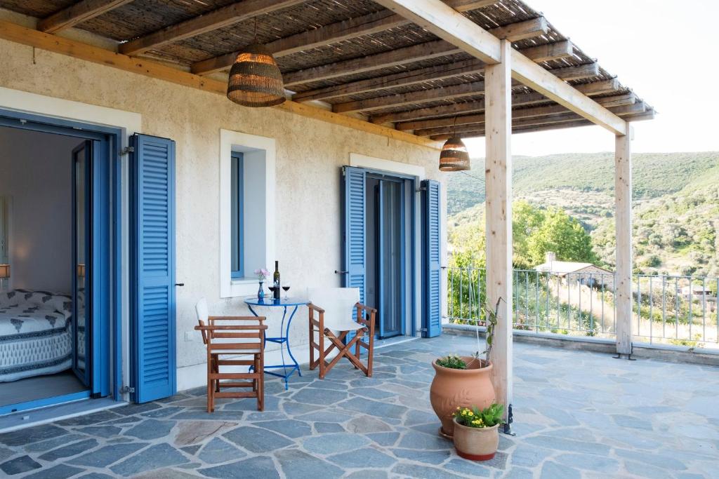 een patio met blauwe deuren en een tafel en stoelen bij O Kipos in Zárakes