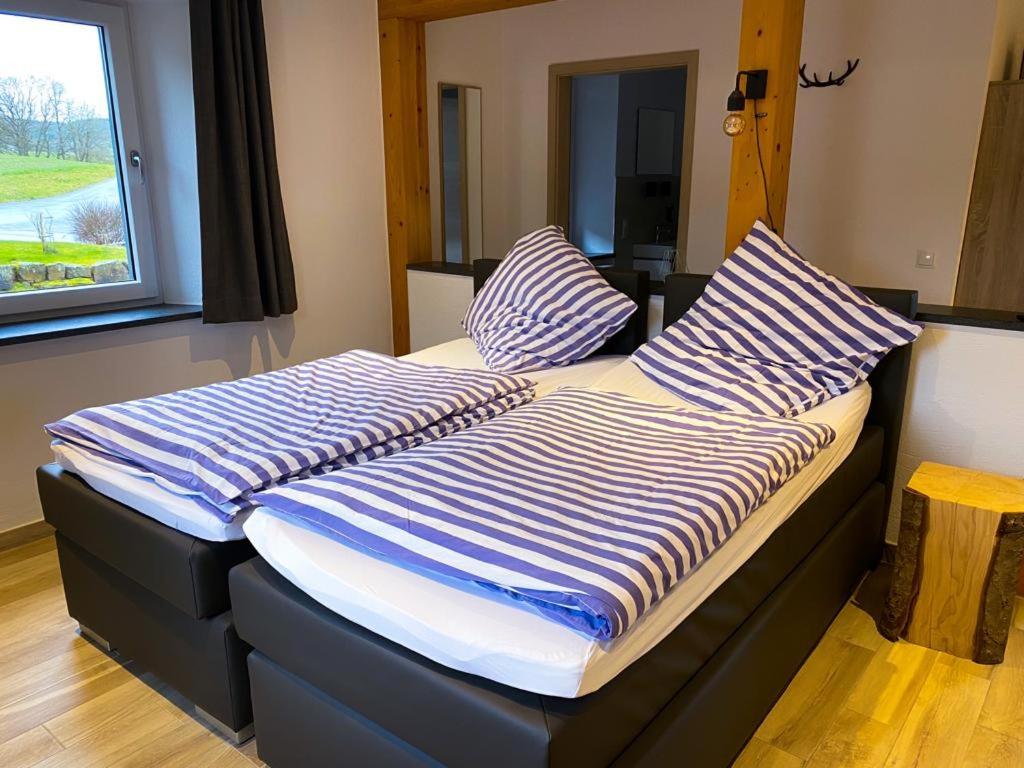 2 camas con almohadas a rayas junto a una ventana en Beim Hooch "Traud", en Brücktal