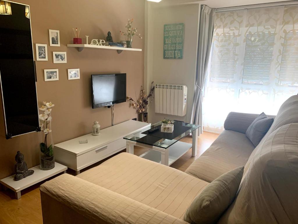 a living room with a couch and a tv at Bermejo Apartamento in Candás
