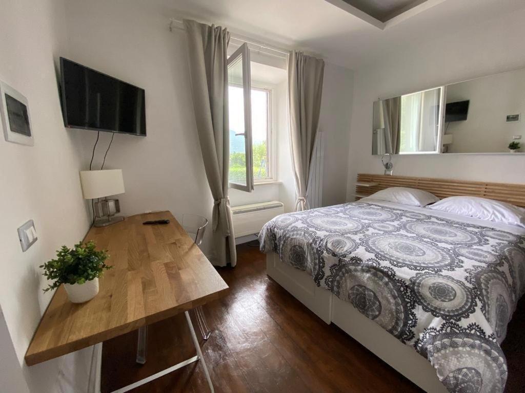 - une chambre avec un lit, une table et une télévision dans l'établissement La Casa con il Bosco, à Castel Gandolfo