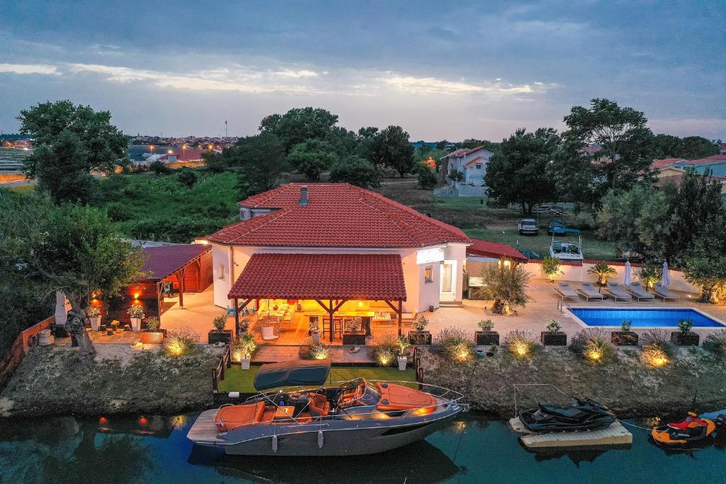 eine Luftansicht eines Hauses mit einem Boot im Wasser in der Unterkunft Villa Rita I in Nin