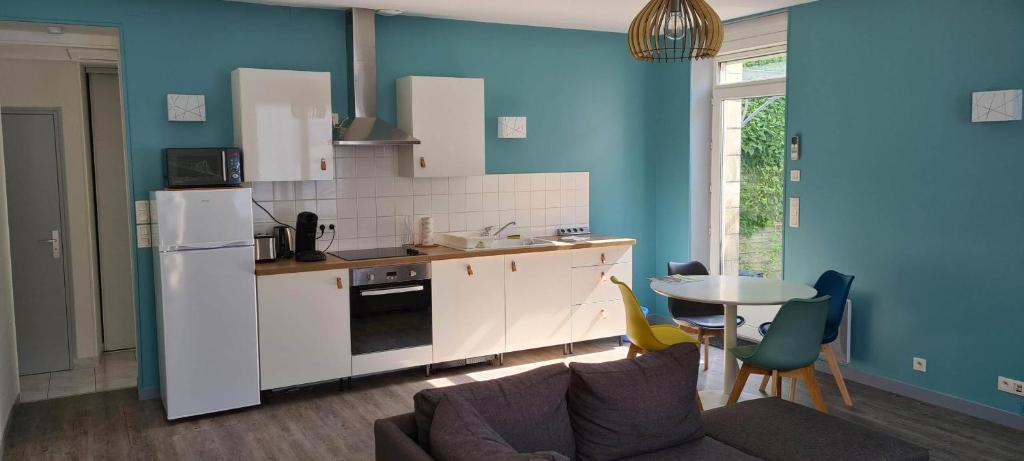 a kitchen with a couch and a table with chairs at Résidence Auger in Bourges