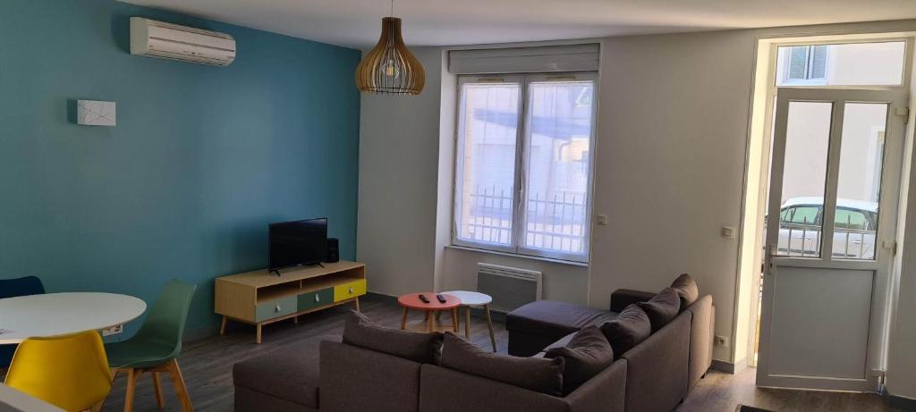 a living room with a couch and a table at Résidence Auger in Bourges