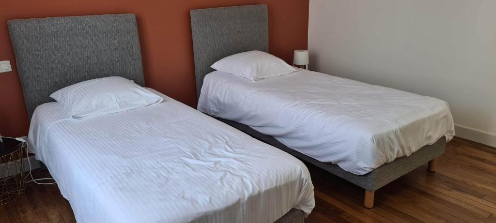 two beds sitting next to each other in a room at Résidence Auger in Bourges