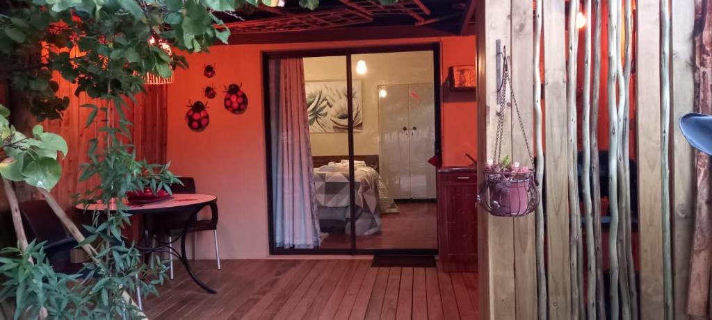 a hallway with orange walls and a room with a bed at Mitat Guesthouse in Beaufort West