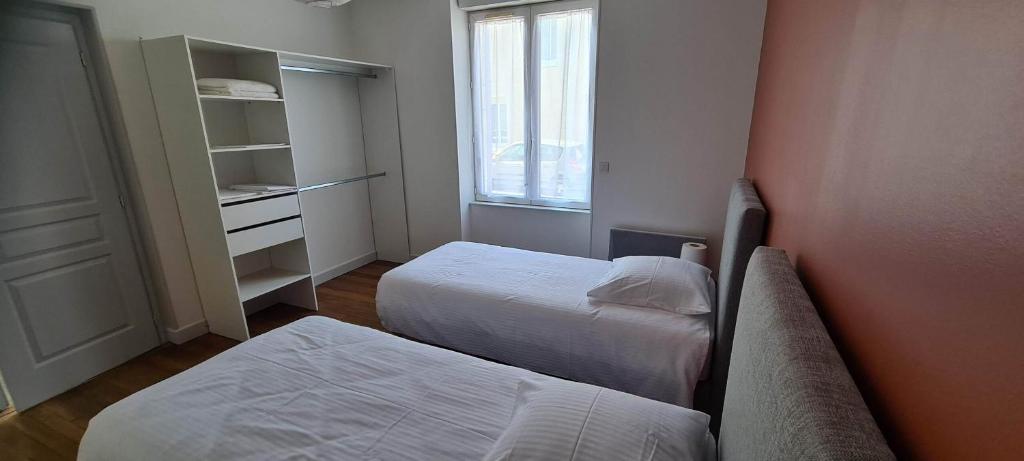 a small bedroom with two beds and a window at Résidence Auger in Bourges