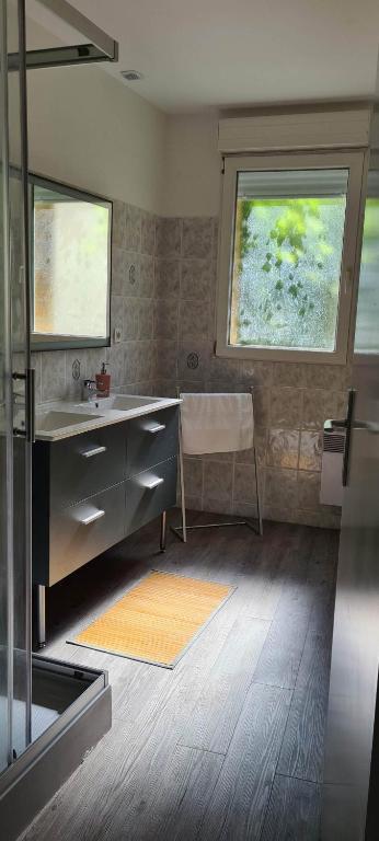 a bathroom with a sink and a desk and a window at Résidence Auger in Bourges
