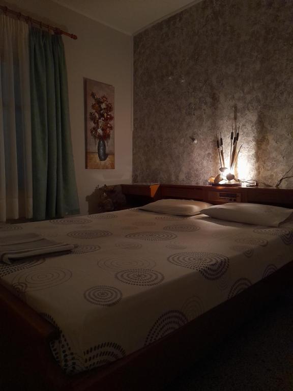 a bedroom with a large bed with a light on it at Antonioy Apartment in Diáva