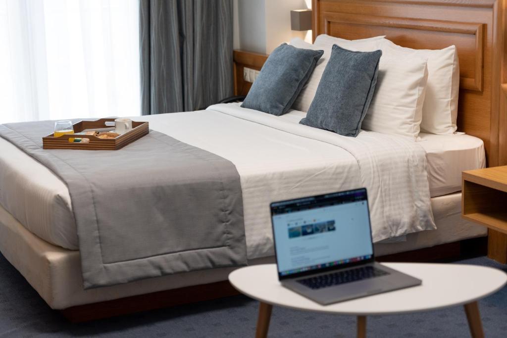 une chambre d'hôtel avec un lit et un ordinateur portable sur une table dans l'établissement Poseidonio, au Pirée