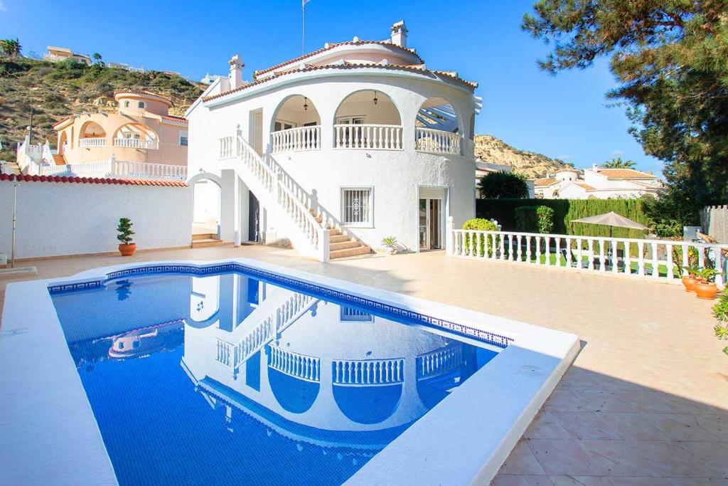 une grande maison avec une piscine en face de celle-ci dans l'établissement CH Villa Golf Park La Marquesa, à Rojales