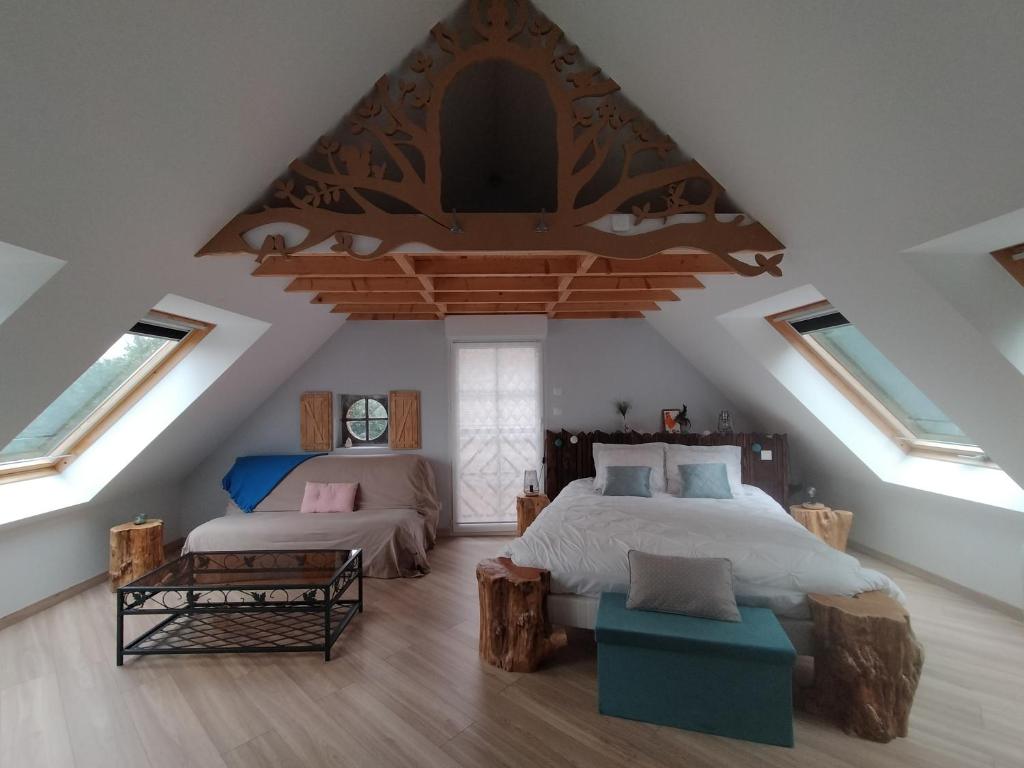 a attic bedroom with two beds and skylights at les Gîtes du Château de Maltot in Saint-Ouen-du-Breuil