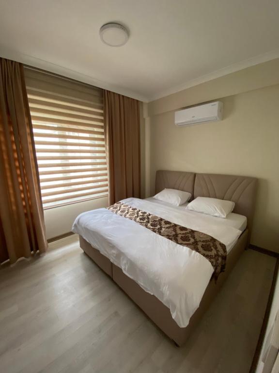 - une chambre avec un grand lit et une fenêtre dans l'établissement BALEK APART, à Pelitli