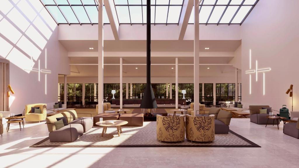 un vestíbulo con muebles y un gran techo de cristal en Hotel Encinar de Sotogrande en Sotogrande