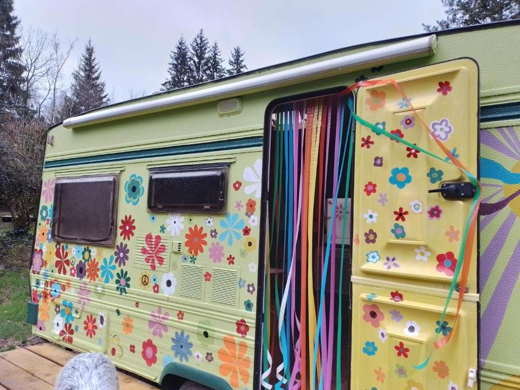 an open door of a caravan with flowers painted on it at la woodstock in Xertigny