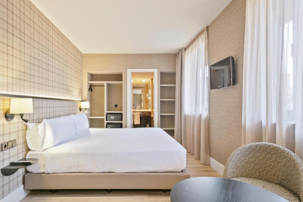 バルセロナにあるアクタ CITY47のベッドと椅子付きのホテルルーム