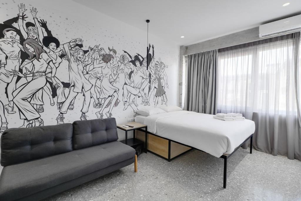 Cette chambre comprend un lit, un canapé et une fresque murale. dans l'établissement athensdot, à Athènes