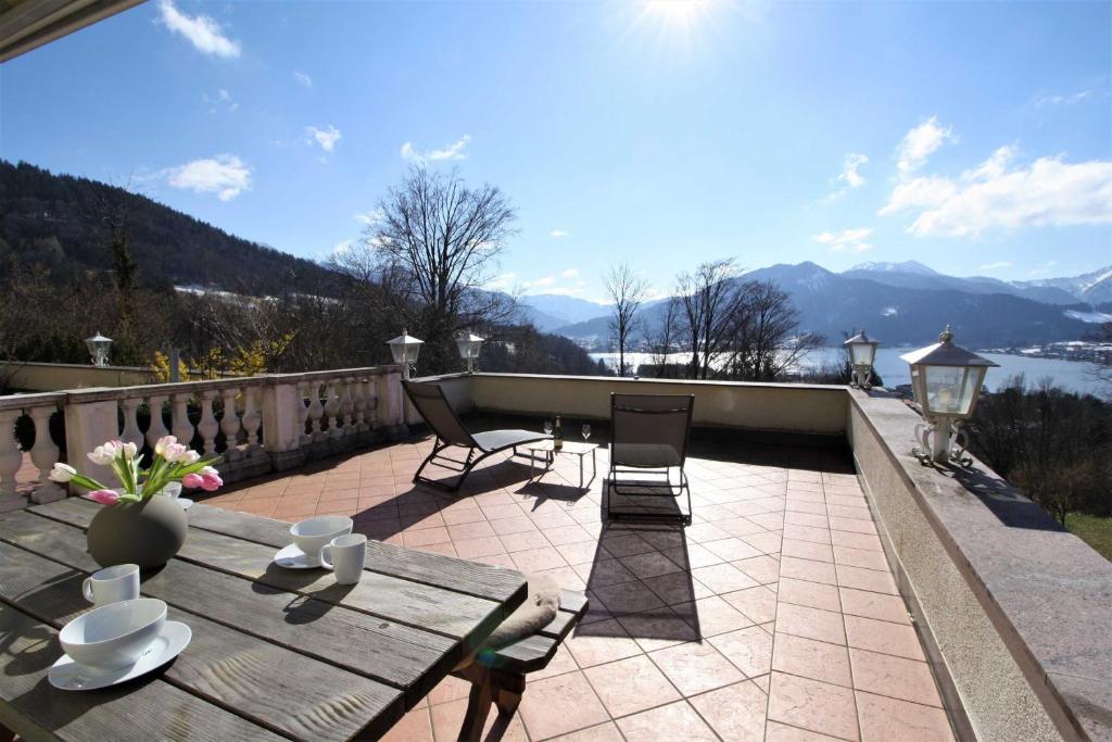 um pátio com uma mesa e cadeiras e vista para as montanhas em Ferienwohnung SeeFugium em Tegernsee