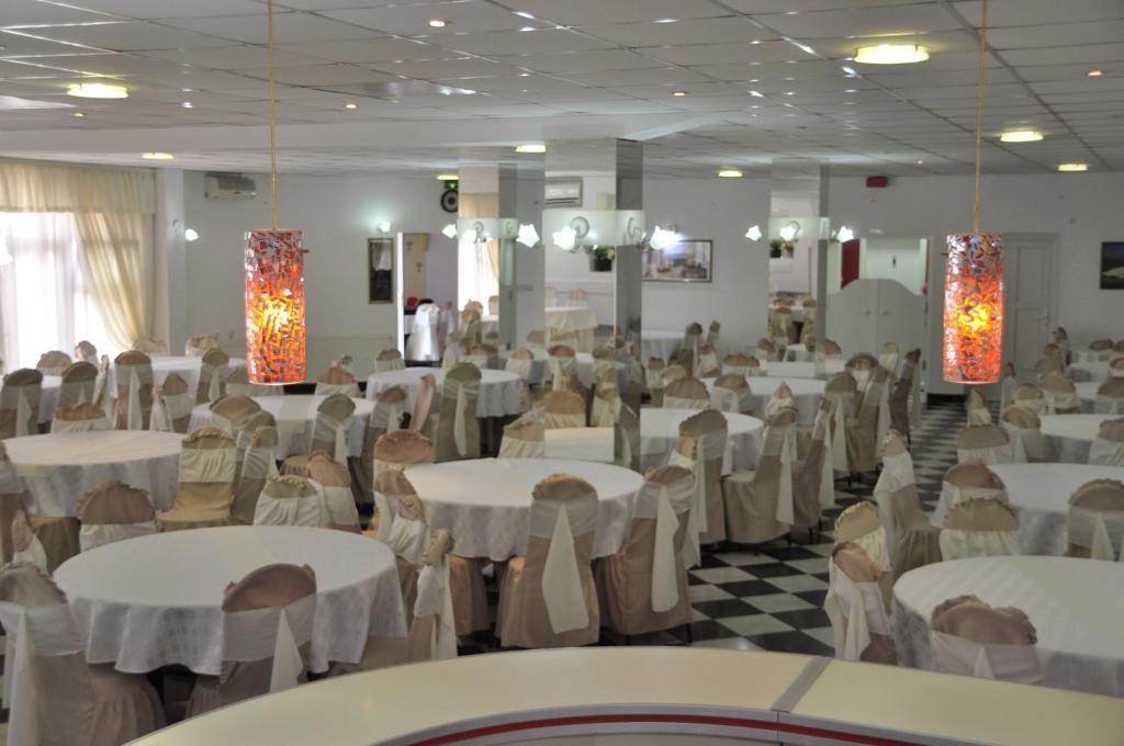 un salón de banquetes con mesas y sillas blancas en PARISKA NOC, en Loznica