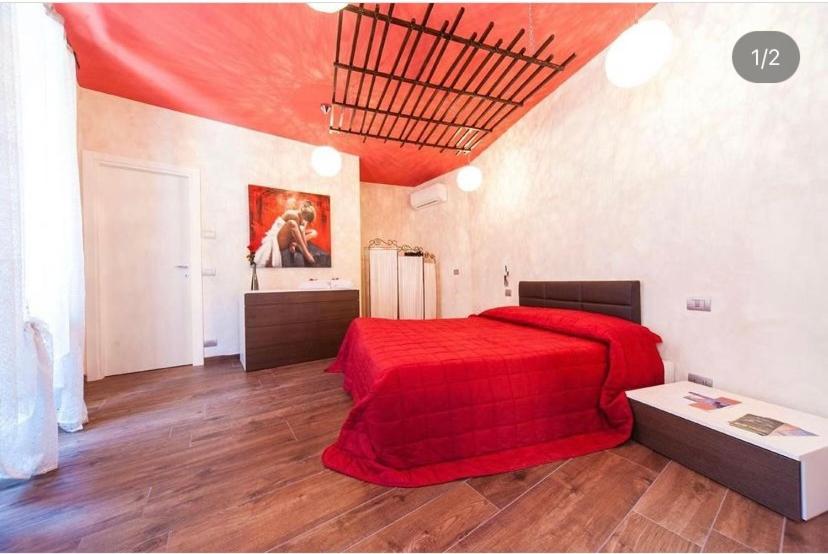a bedroom with a red bed with a red blanket at B&B BuongiornoNotte in Bobbio