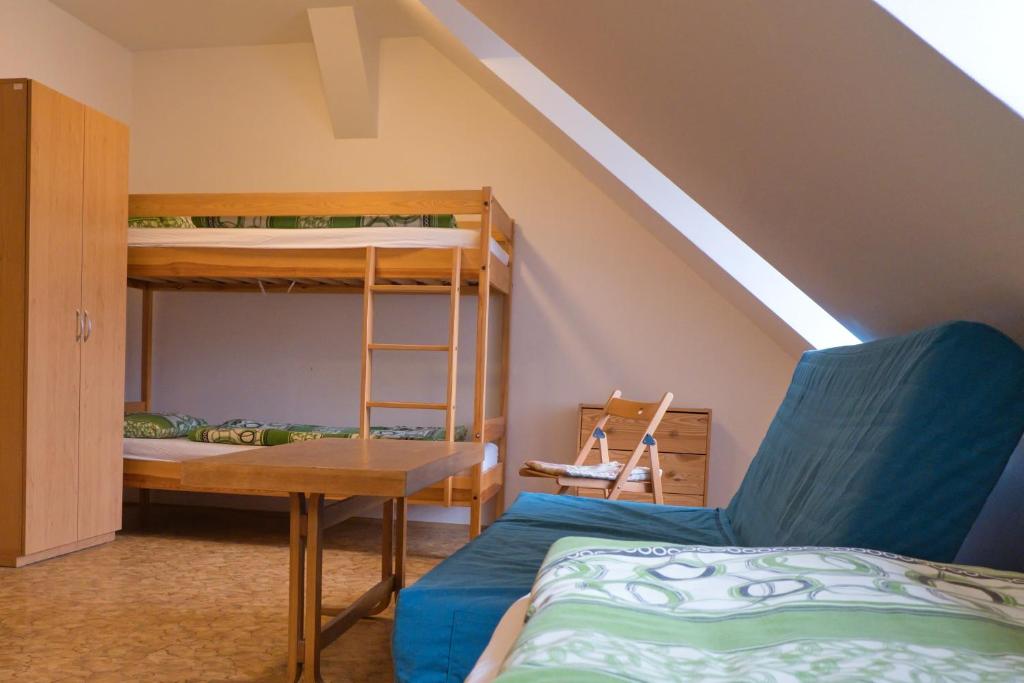 a bedroom with bunk beds and a table and a desk at Ubytovna Toulcův dvůr in Prague