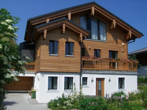 a wooden house with a balcony on top of it at Appartement Asitz in Leogang