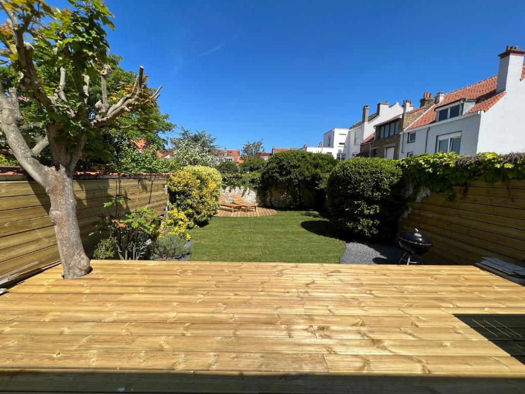 una terraza de madera con un árbol en un patio en Malie & Macha - Jolie Maison à Malo-les-Bains en Dunkerque