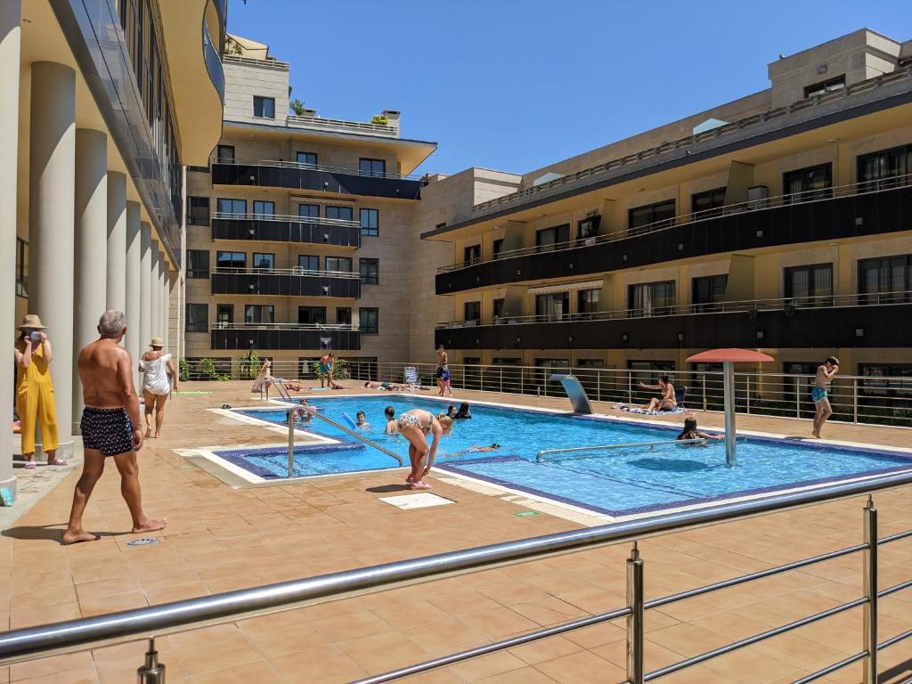 a group of people standing around a swimming pool at FLATSELECT Pinamar in Sanxenxo